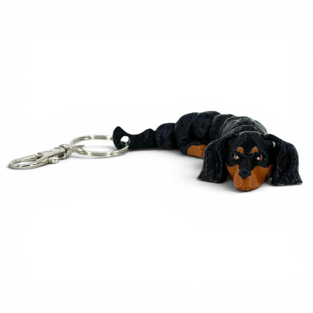 Black and brown dog-shaped keychain on a white background