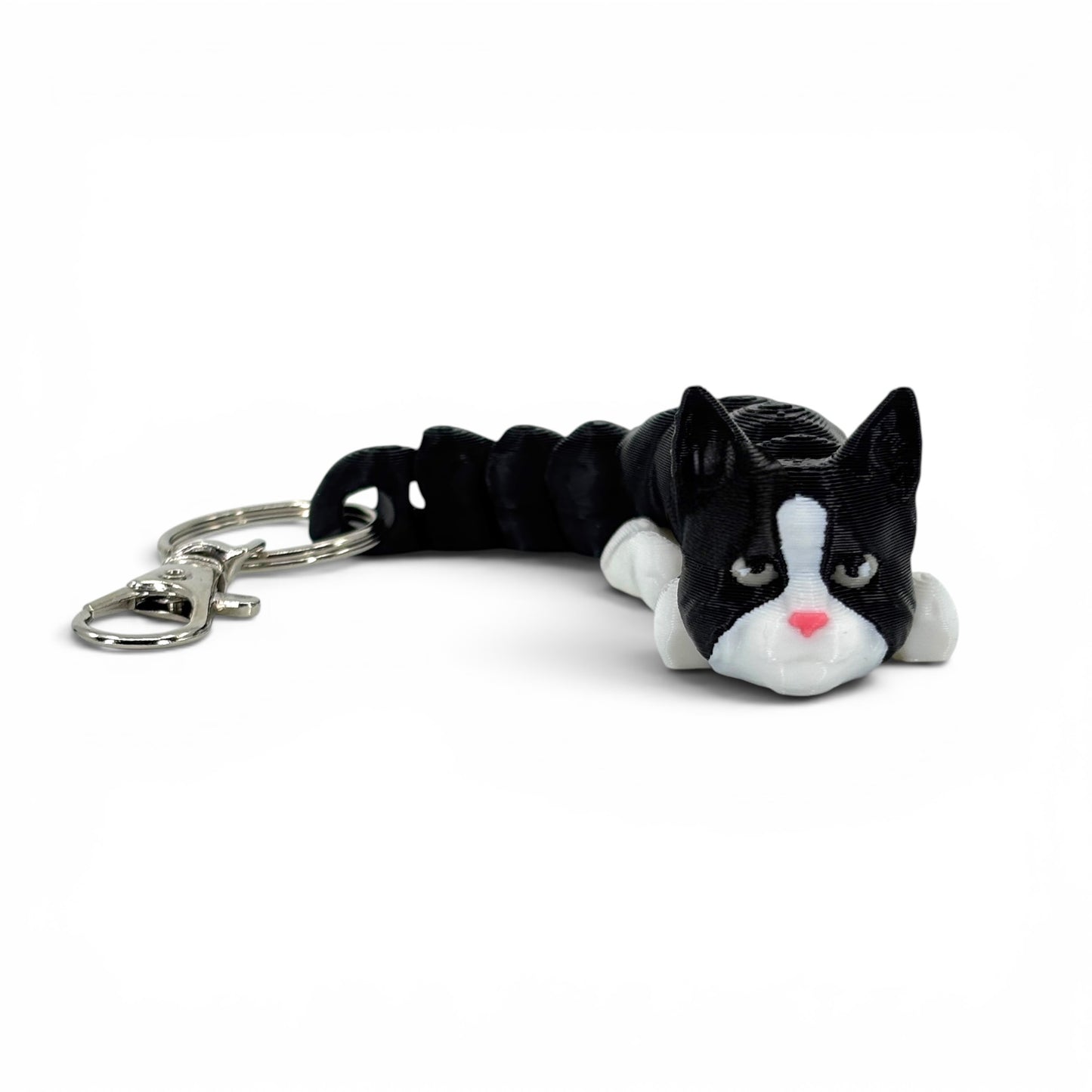 Black and white cat with pink nose keychain on a white background