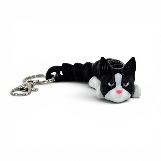 Black and white cat with pink nose keychain on a white background