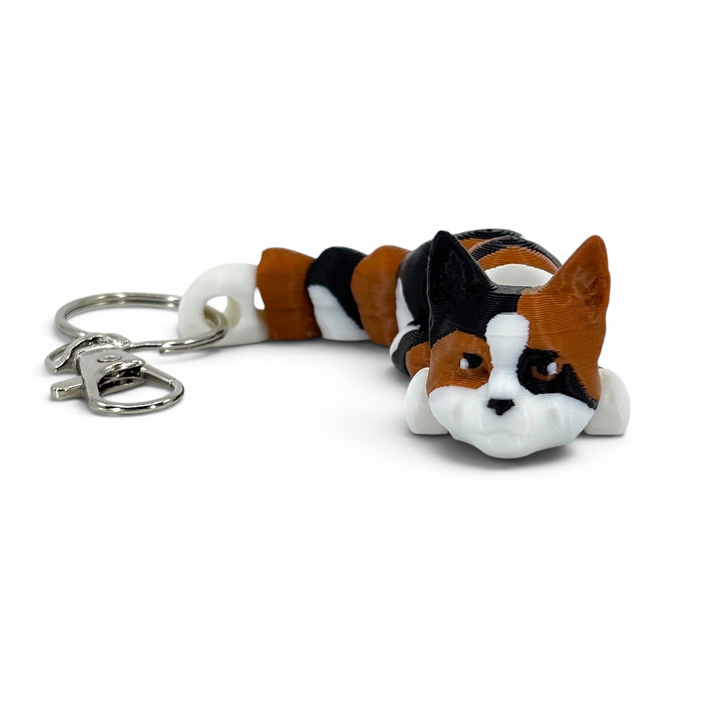 Cat-shaped keychain with a white, black, and brown color pattern on a white background