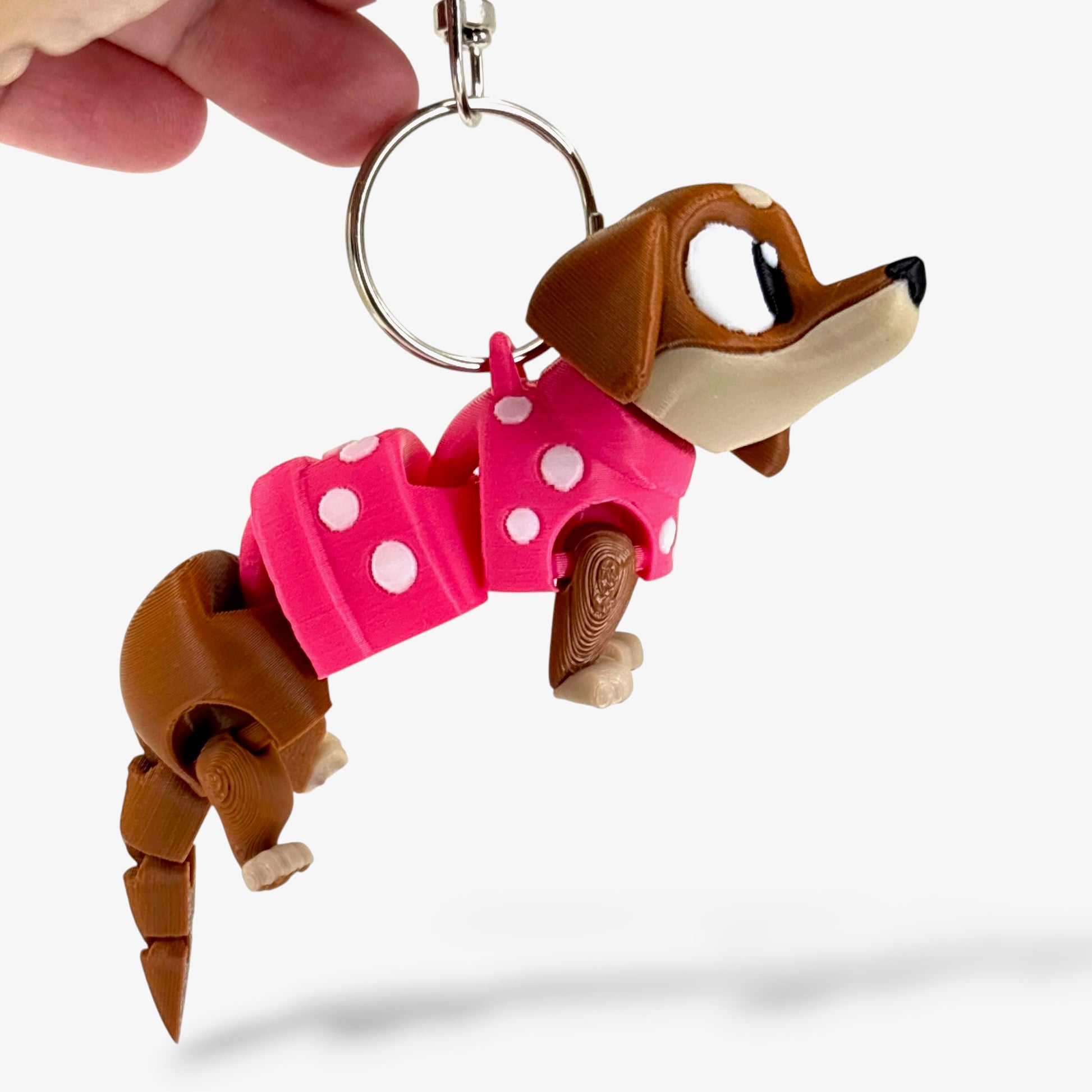Dachshund with large eyes keychain in a pink polka dot sweater on a white background