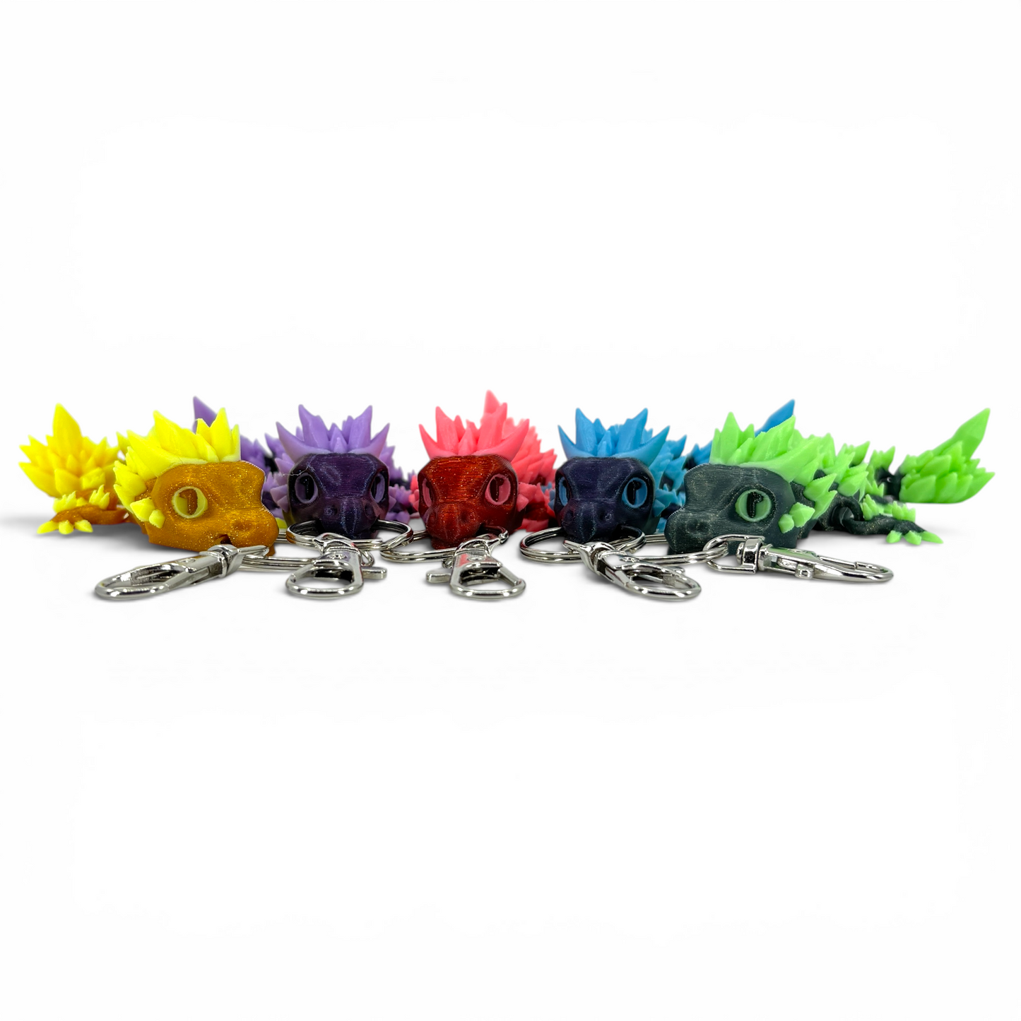 Colorful crystal dragon keychains arranged in a row on a white background