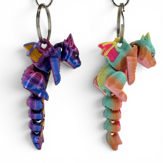 Two colorful dragon-shaped keychains on a white background