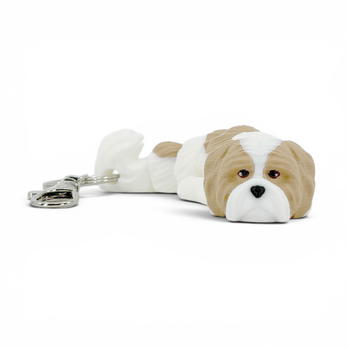 Shih Tzu Dog Keychain front view colored in beige and white on surface.