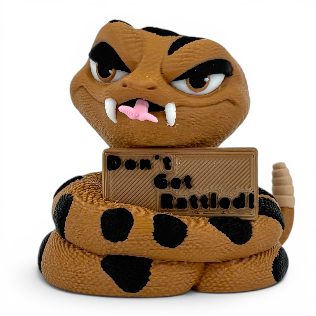 3D printed rattlesnake with a sign saying 'Don't Get Rattled!' on a white background