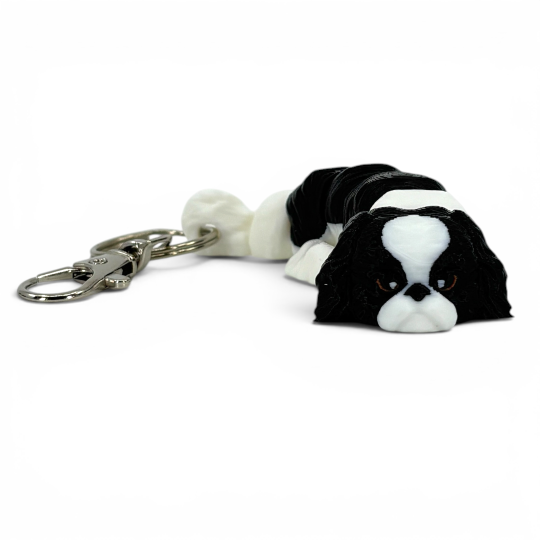 Black and white dog-shaped keychain on a white background